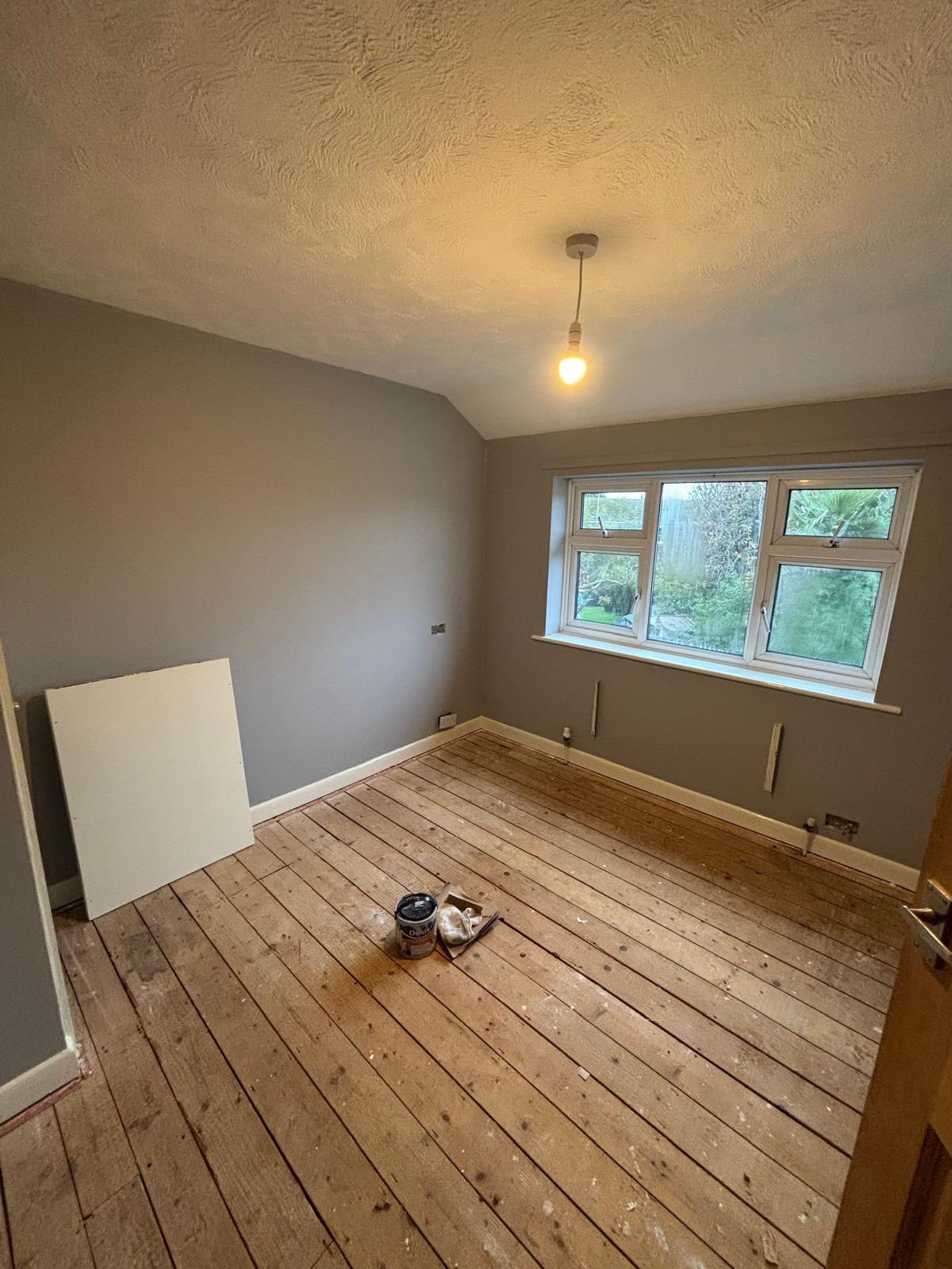 Room with wooden flooring and freshly painted walls
